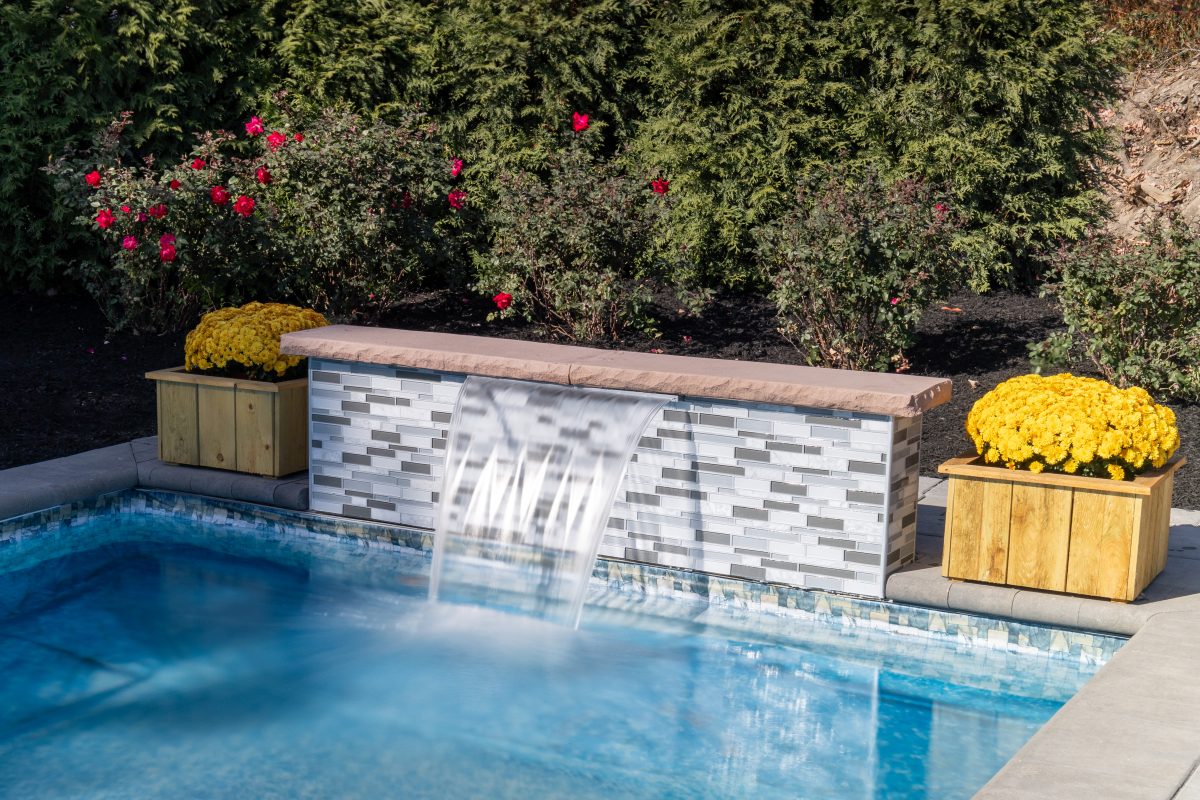 A beautiful modern formal waterfall kit flowing into a swimming pool