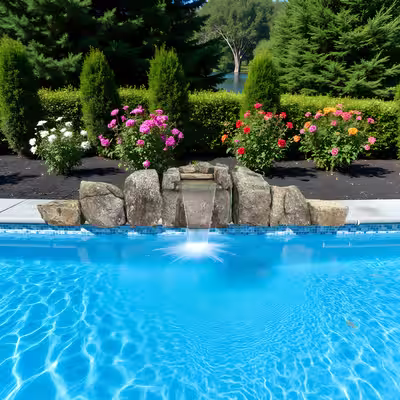 Engineered natural stone pool waterfall kit 1016 set into poolside landscaping