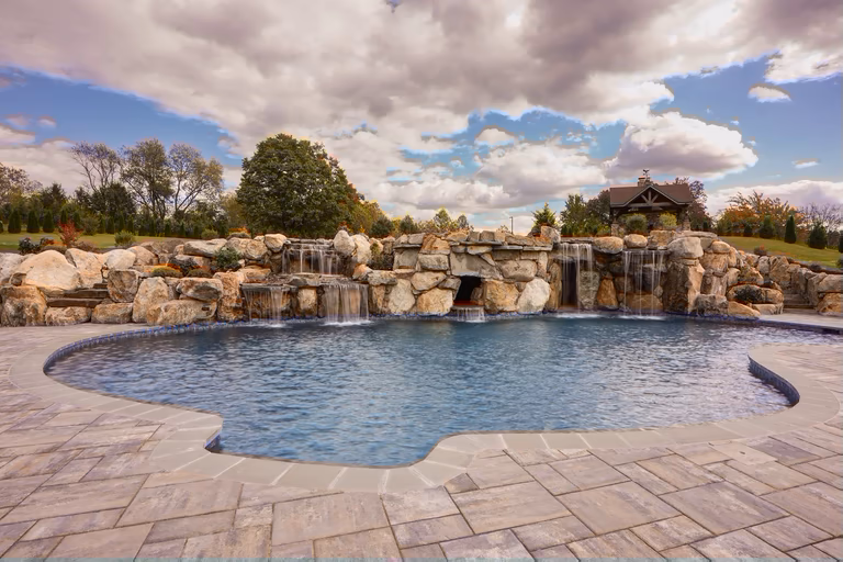 Natural stone spa waterfall spilling into a pool