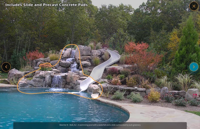 Multi-tiered natural stone boulder waterfall cascading into a freeform pool with lush ornamental landscaping