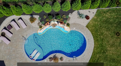 Multi-tiered natural stone boulder waterfall cascading into a freeform pool with lush landscaping