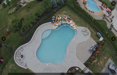 Multi-tiered natural stone boulder waterfall cascading into a freeform pool with integrated floral plantings