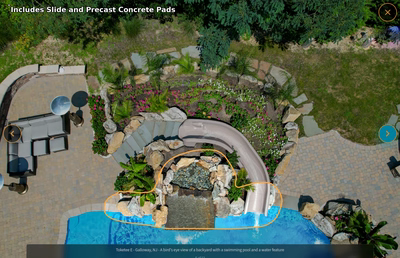 Multi-tiered natural stone boulder waterfall cascading into a pool with lush tropical landscaping