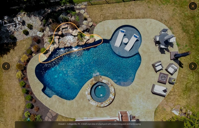 Multi-tiered natural stone boulder waterfall cascading into a freeform pool with integrated rock landscaping