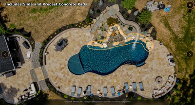 Multi-tiered natural stone boulder waterfall cascading into a freeform pool with lush greenery