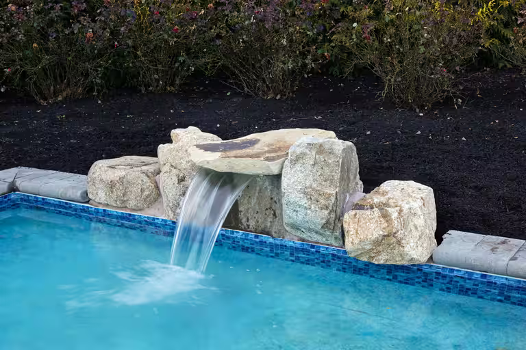 Genesis natural stone waterfall kit installed beside a pool