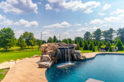 Patterson C - Medford, NJ - A swimming pool with a waterfall in the middle of it surrounded by lush green grass and trees