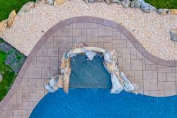 Patterson H - Medford, NJ - A bird's eye view of a swimming pool with a waterfall and a stone pathway