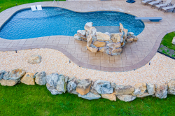 Patterson I - Medford, NJ - A rectangular swimming pool surrounded by a stone retaining wall and lush green grass
